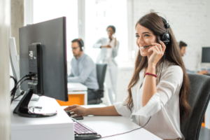 une téléconseillère qui écoute son client et qui rigole